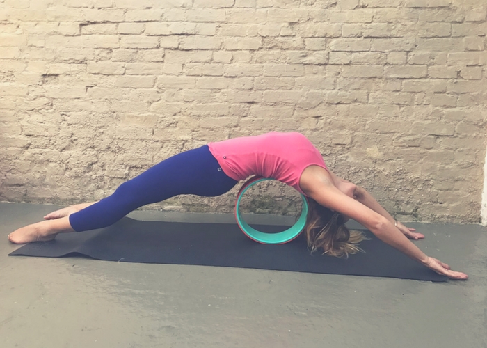 stretching out front side of body on yoga wheel
