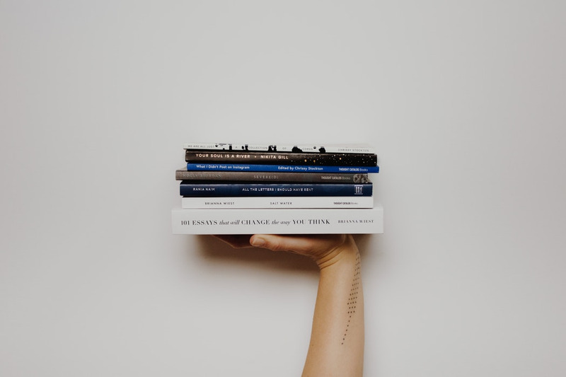 hand with books balanced on it