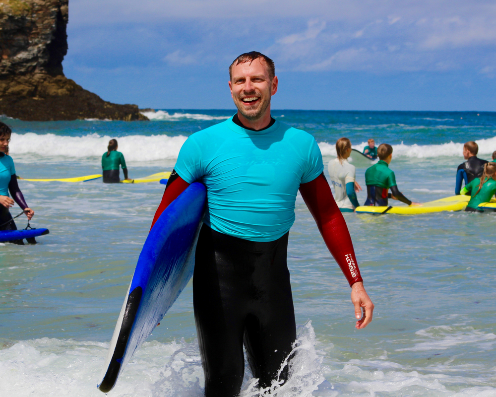 guest holding surf board cornwall yoga retreat