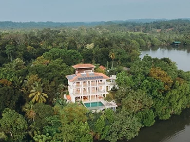 large villa surrounded by trees and a lake in sri lanka