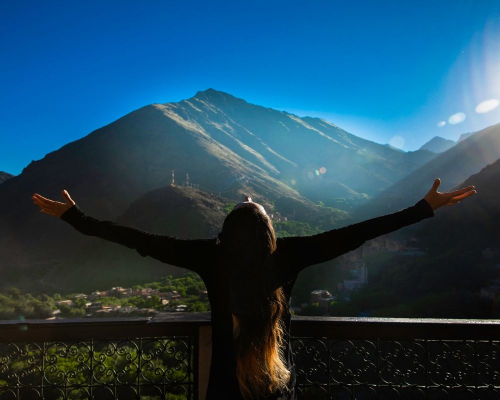 girl arms wide head up in atlas mountains