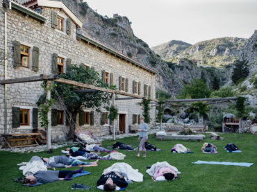 people in savasana outside front of olive mill accommodation - hiking yoga holiday montenegro