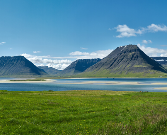 Iceland summer landscape mountains, lake, houses