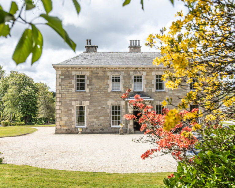 front of manor house with bushes