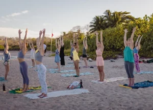 people doing yoga on the beach in costa rica