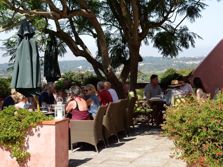 people sat on a terrace outside eating lunch